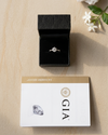 Diamond ring in a black box with GIA card on a wooden surface
